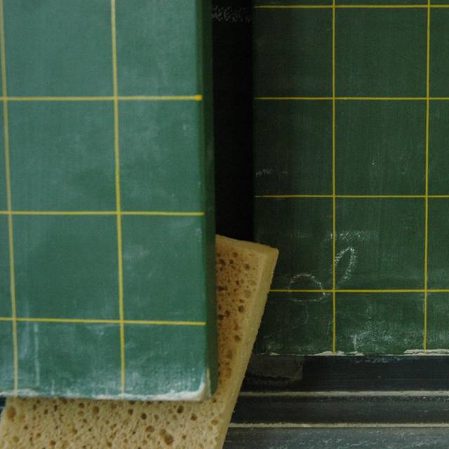 Tafel mit eingeklemmten Schwamm und Kreide