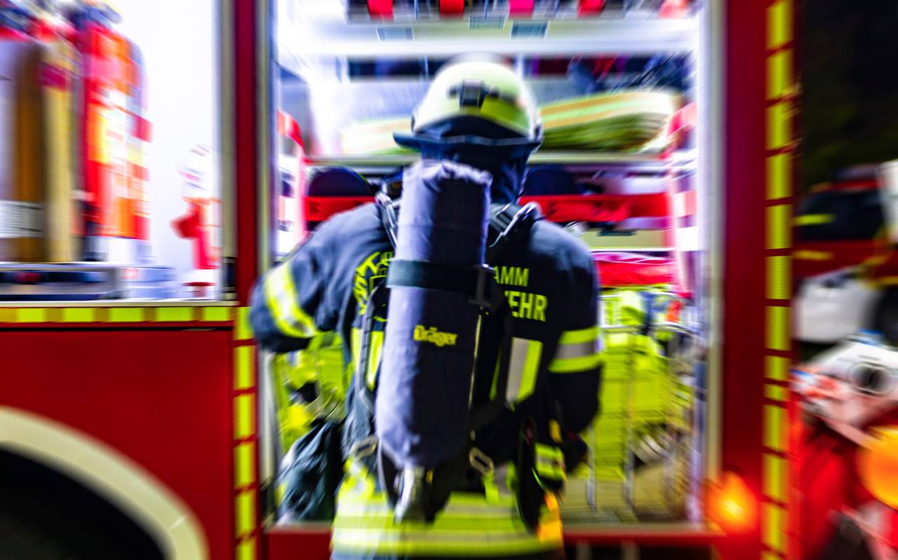Ein Feuerwehrmann aus Hamm entnimmt einen Schlauchtragekorb. (Symbolfoto)