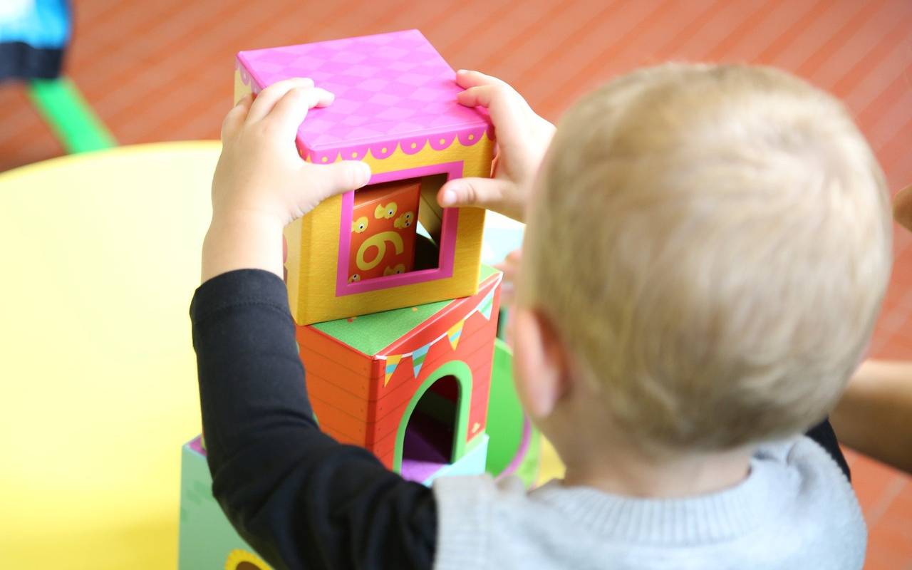 Ein Kind von hinten, das mit Bauklötzen spielt.