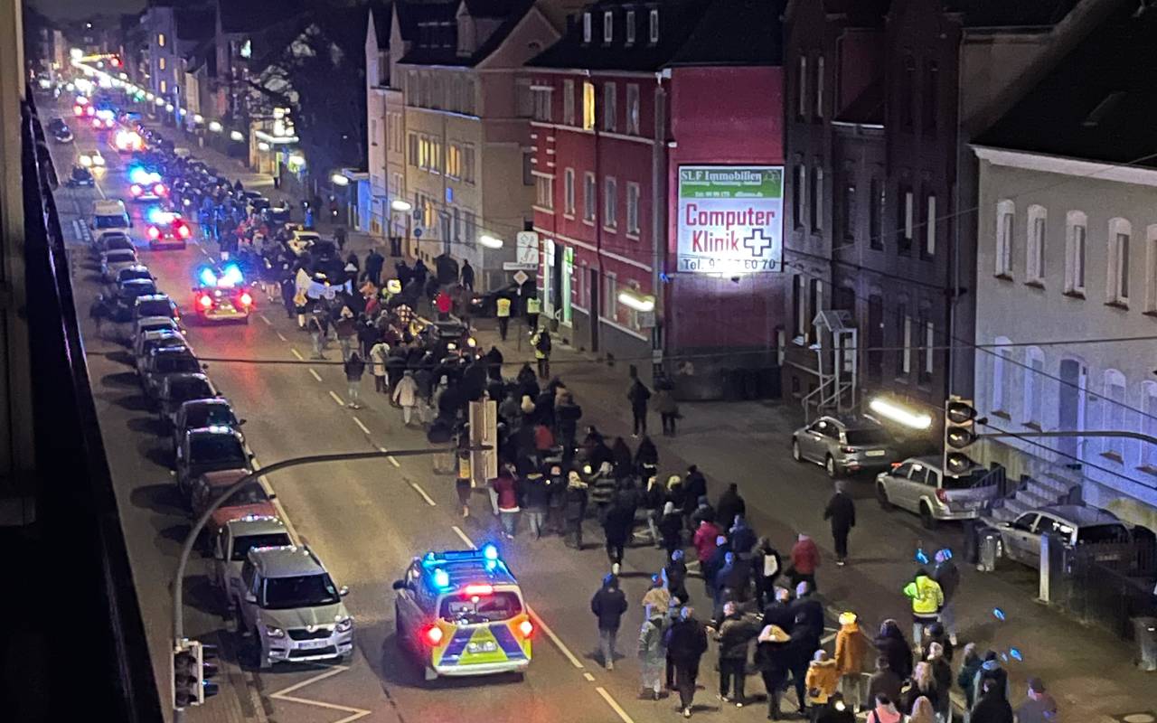 Fast 500 Hammer laufen in einer Demo über die Werler Straße am Abend, begleitet von mehreren Polizeiwagen.