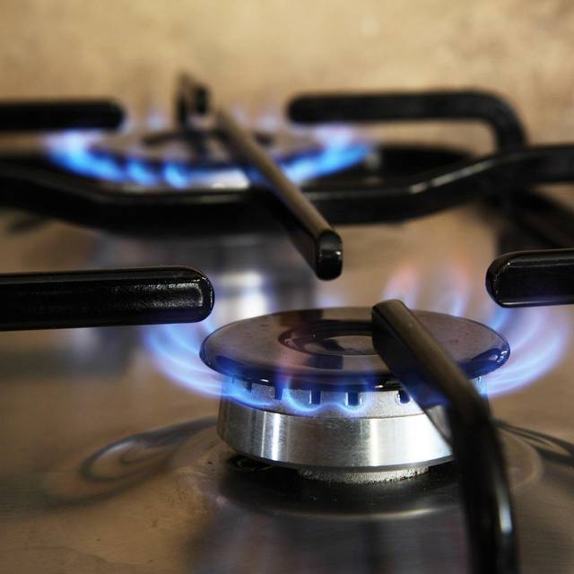 Zwei Platten eines Gasherdes mit Flamme.