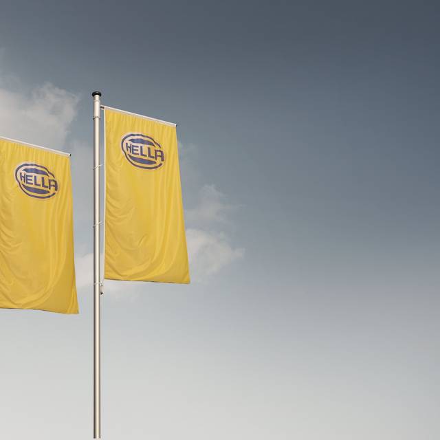 drei Fahnen mit dem Hella Logo blau auf gelben Grund