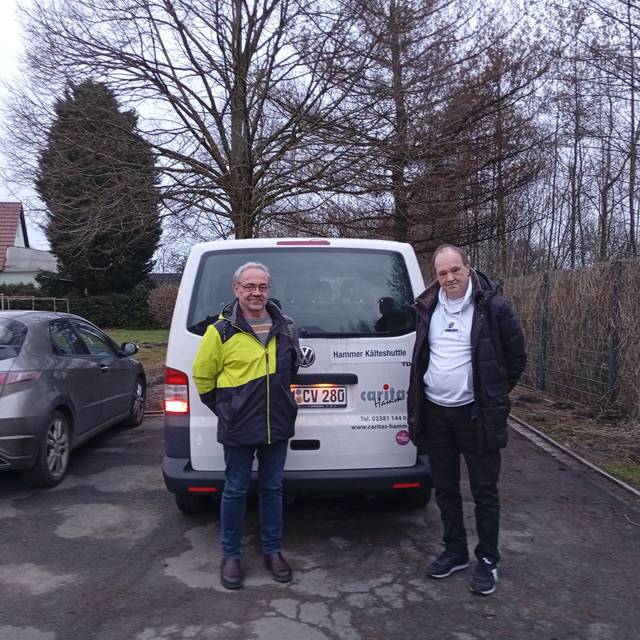 Berthold Schöpe (l.), Caritas-Fachbereichsleiter Soziale Dienste, und der Ehrenamtliche Michael Kuppe (r.) vor dem Kälteshuttle-Bus der Caritas Hamm.