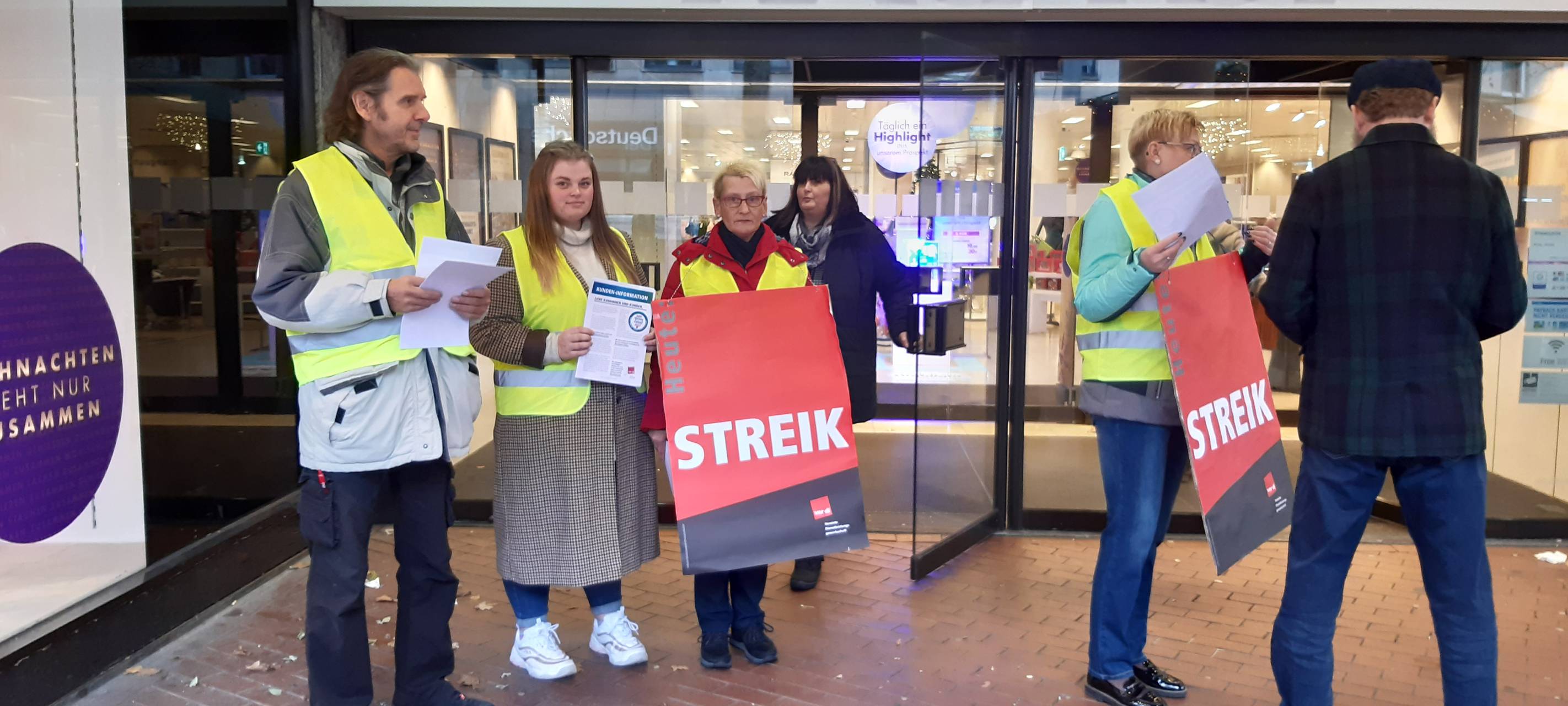Vor dem Geschäft werben die Mitarbeiter für ihre Forderung.