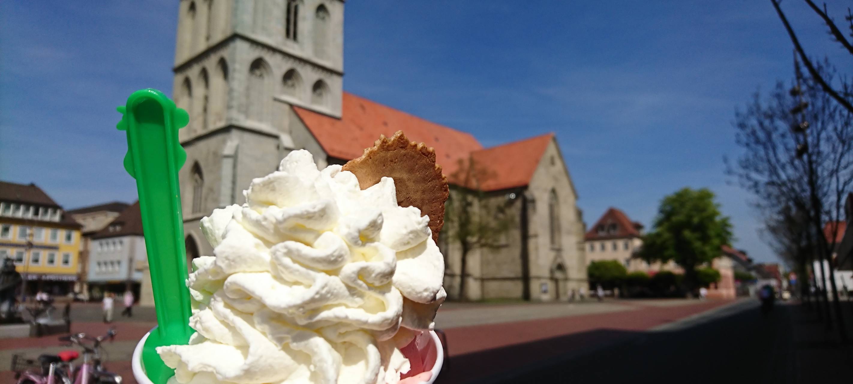 Ein Becher mit zwei Kugeln Eis und Sahne vor der Pauluskirche in der Hammer Innenstadt.