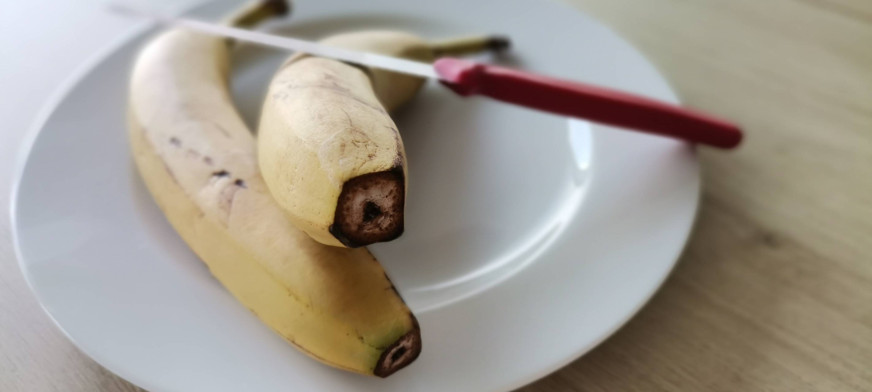 Bananen auf einem Teller vorne angeschnitten
