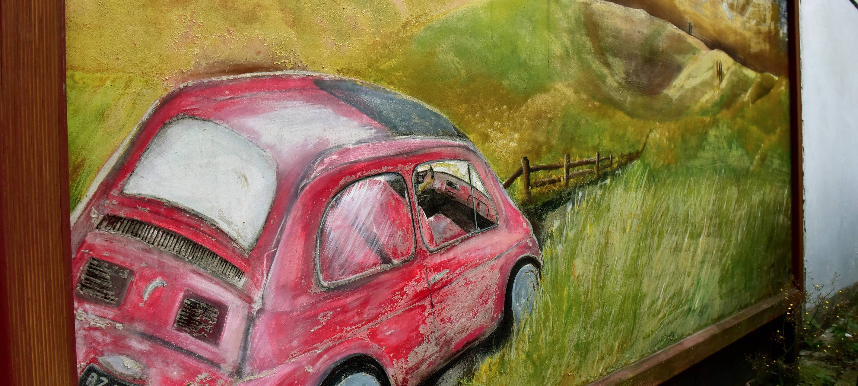 Ein Gemälde eines Autos an einer Hauswand.