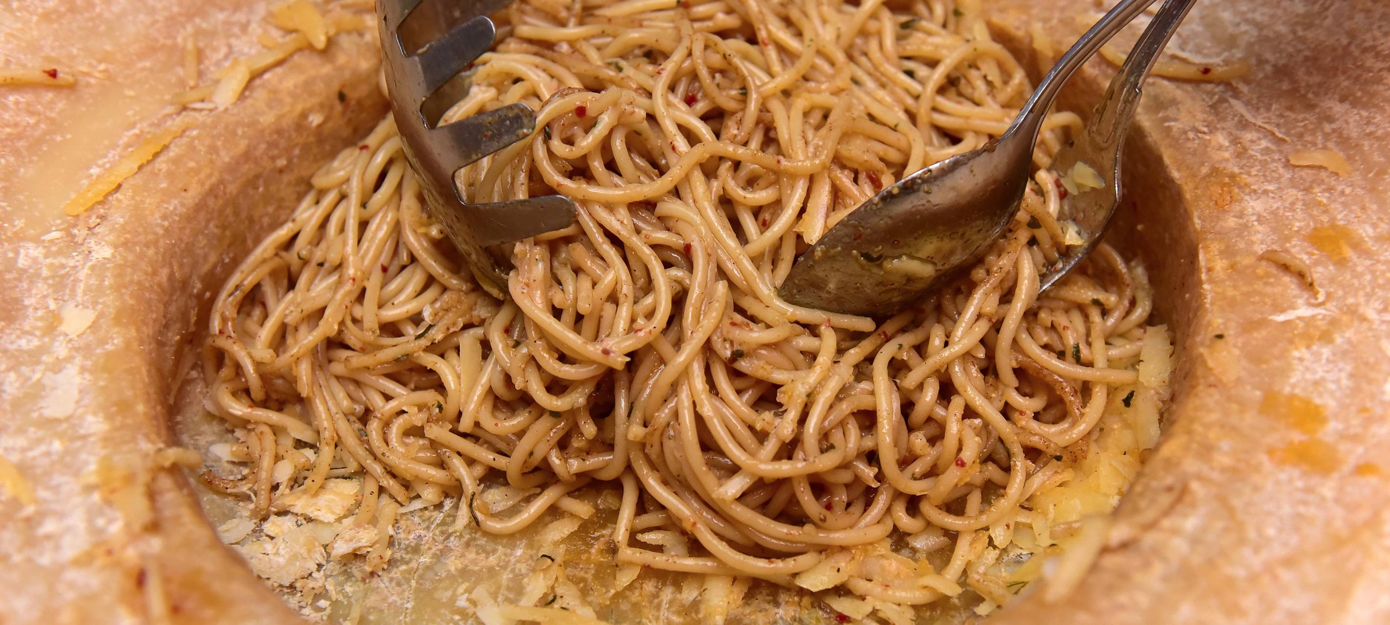 Eine Portion Spaghetti liegt in einem Käse-Laib.