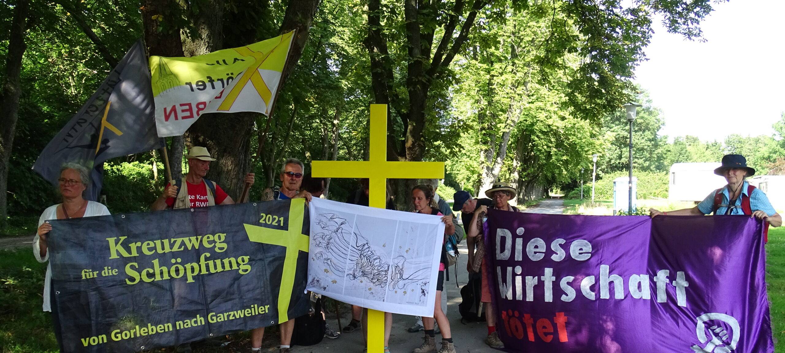 Teilnehmer des Kreuzwegs präsentieren ihre Banner.