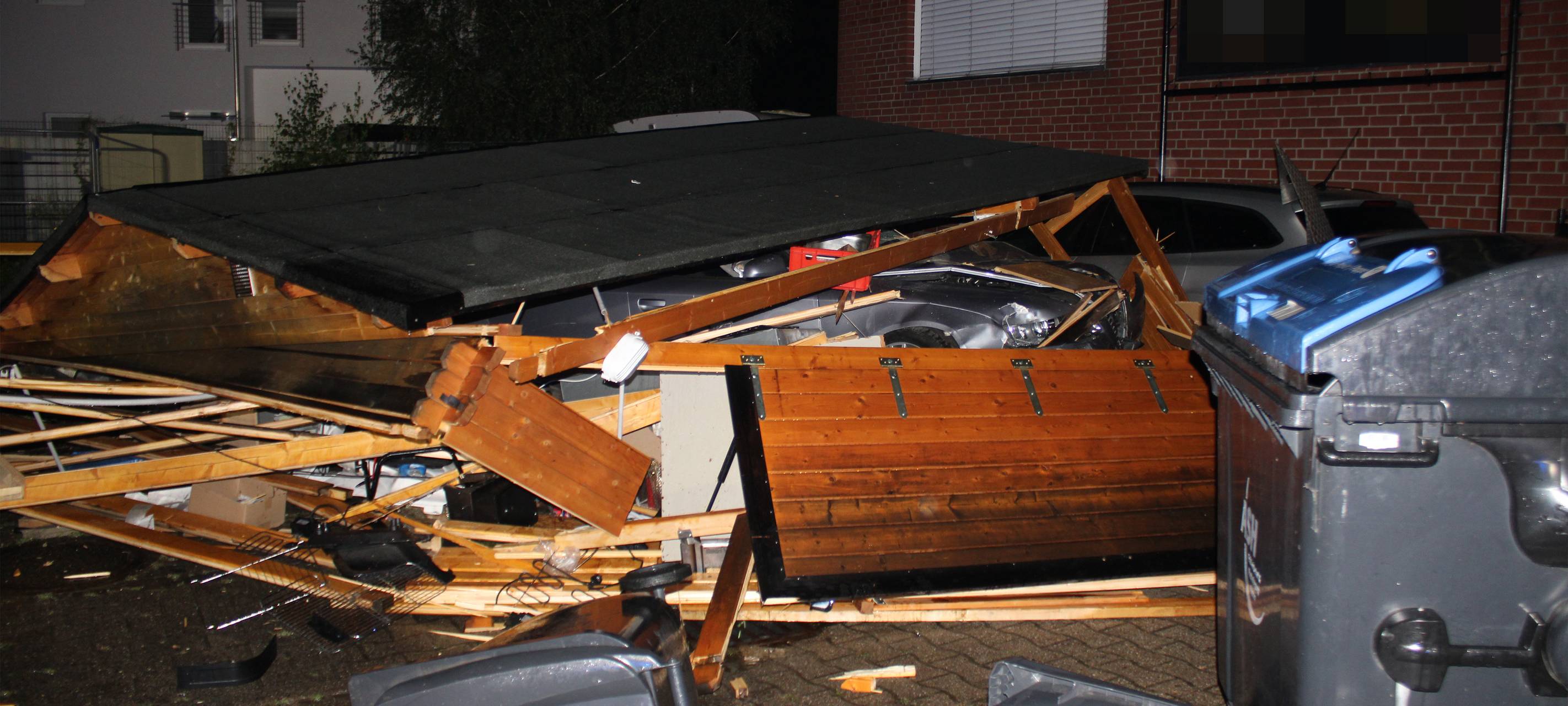 Auto in Trümmern einer Holzhütte