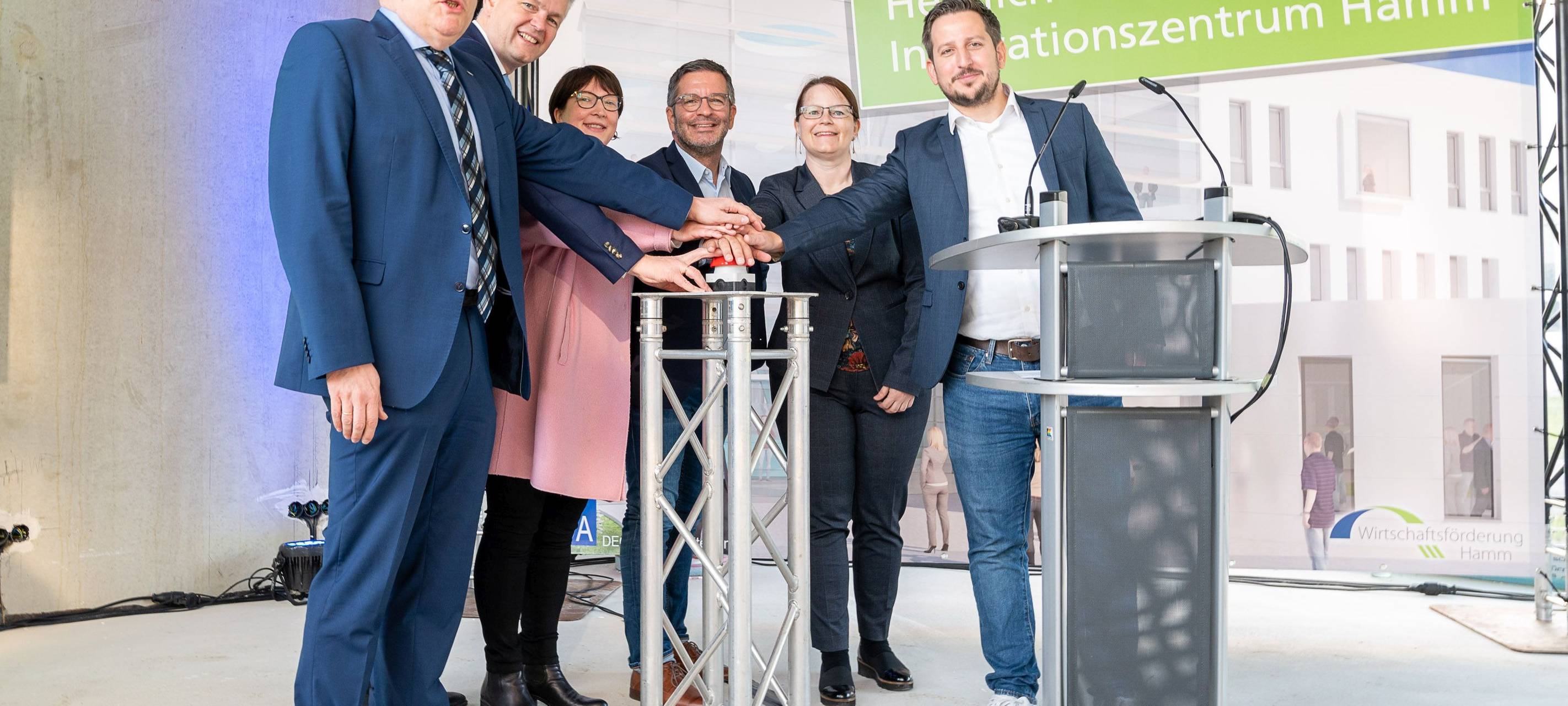 Beteiligte stehen vor Innovationszentrums Plakat