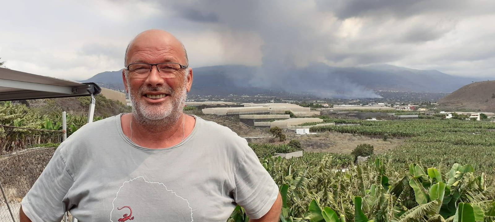 Berthold Kernberg aus Hamm auf seinem Grundstück auf La Palma, Hintergrund qualmender Vulkan