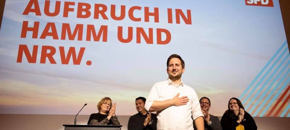 Justus Moor steht auf einer Bühne.