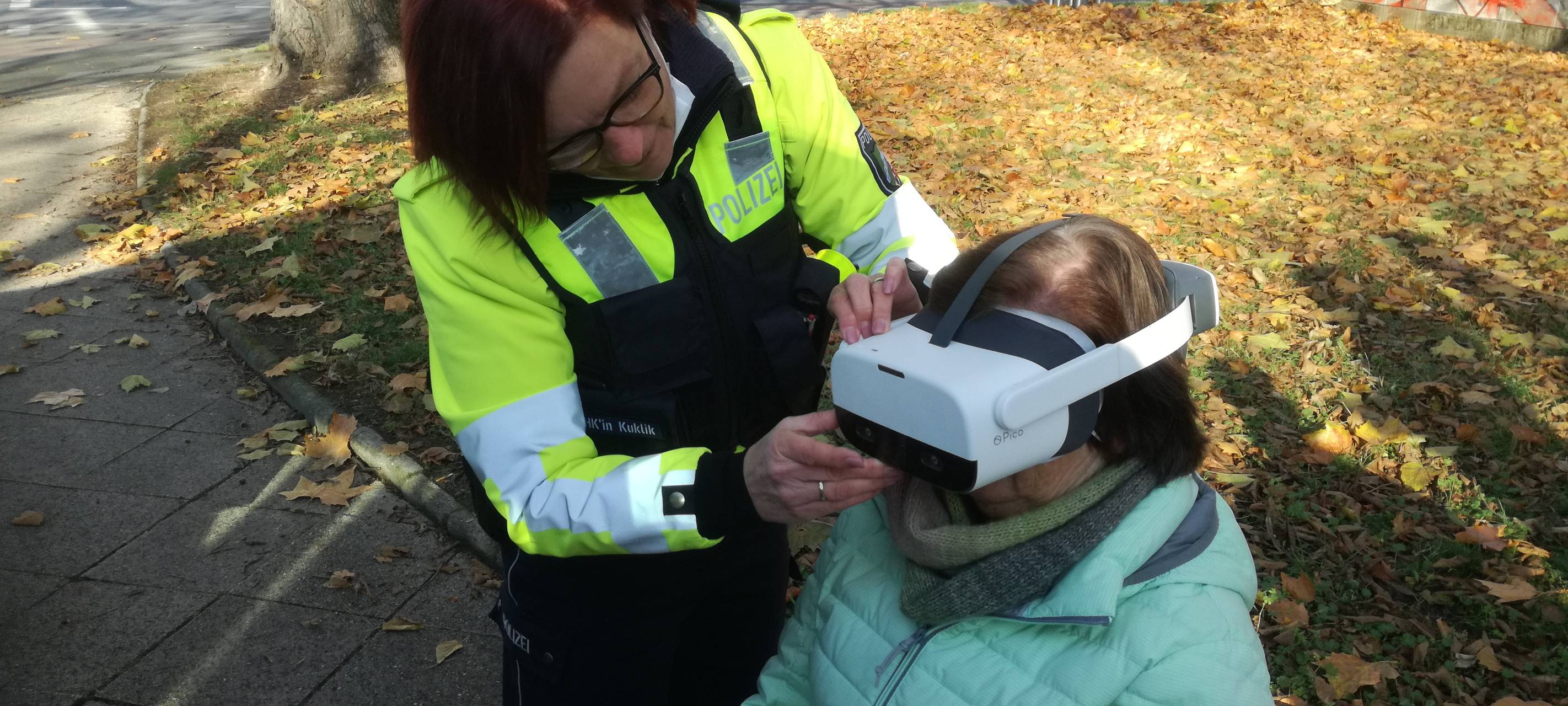 Eine Polizistin und eine Passantin, die eine VR-Brille testet.