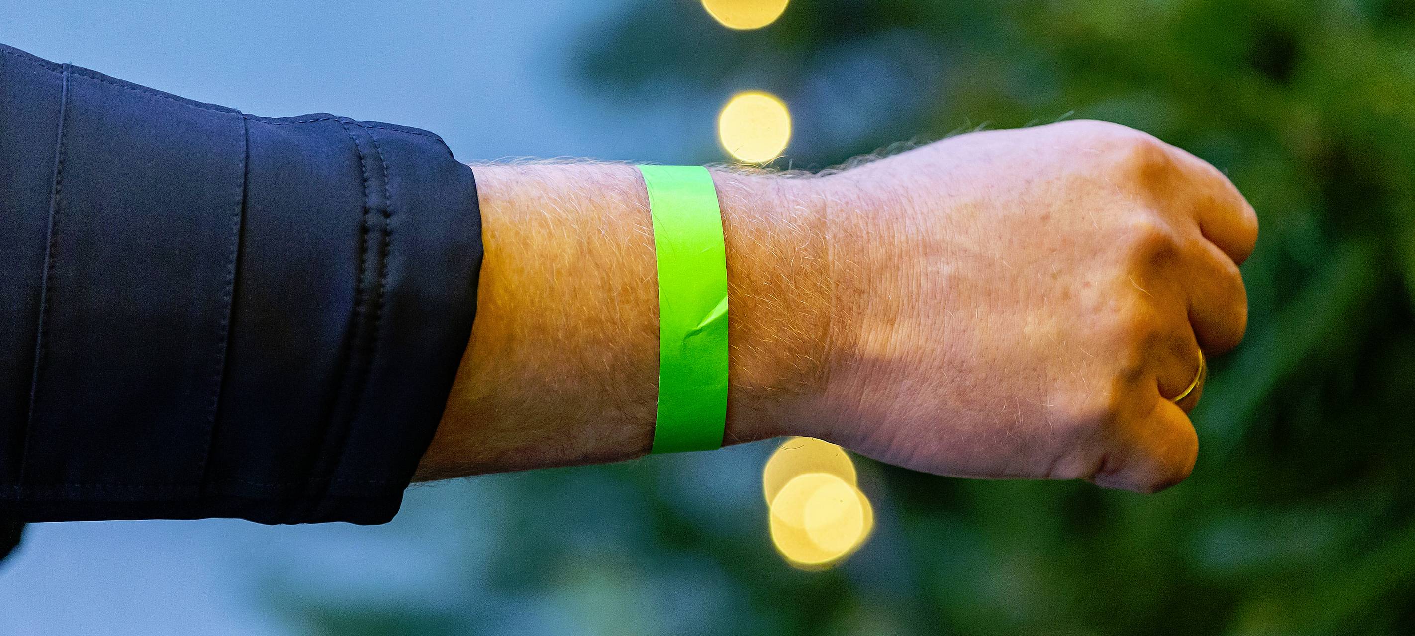 Ein grünes 2G-Bändchen am Arm eines Mannes.