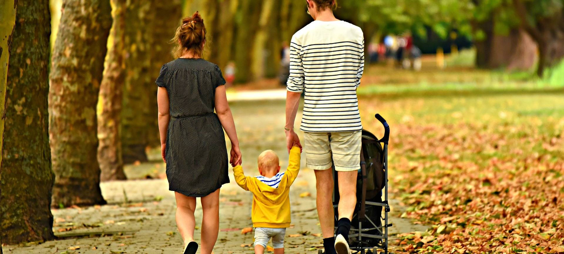 Eine Familie beim Spaziergang durch einen Wald.