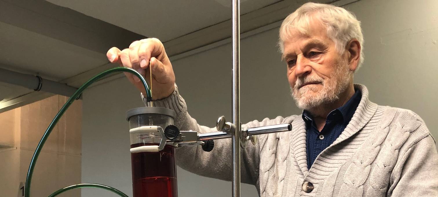 Mann macht chemische Experimente mit einer dunken Flüssigkeit