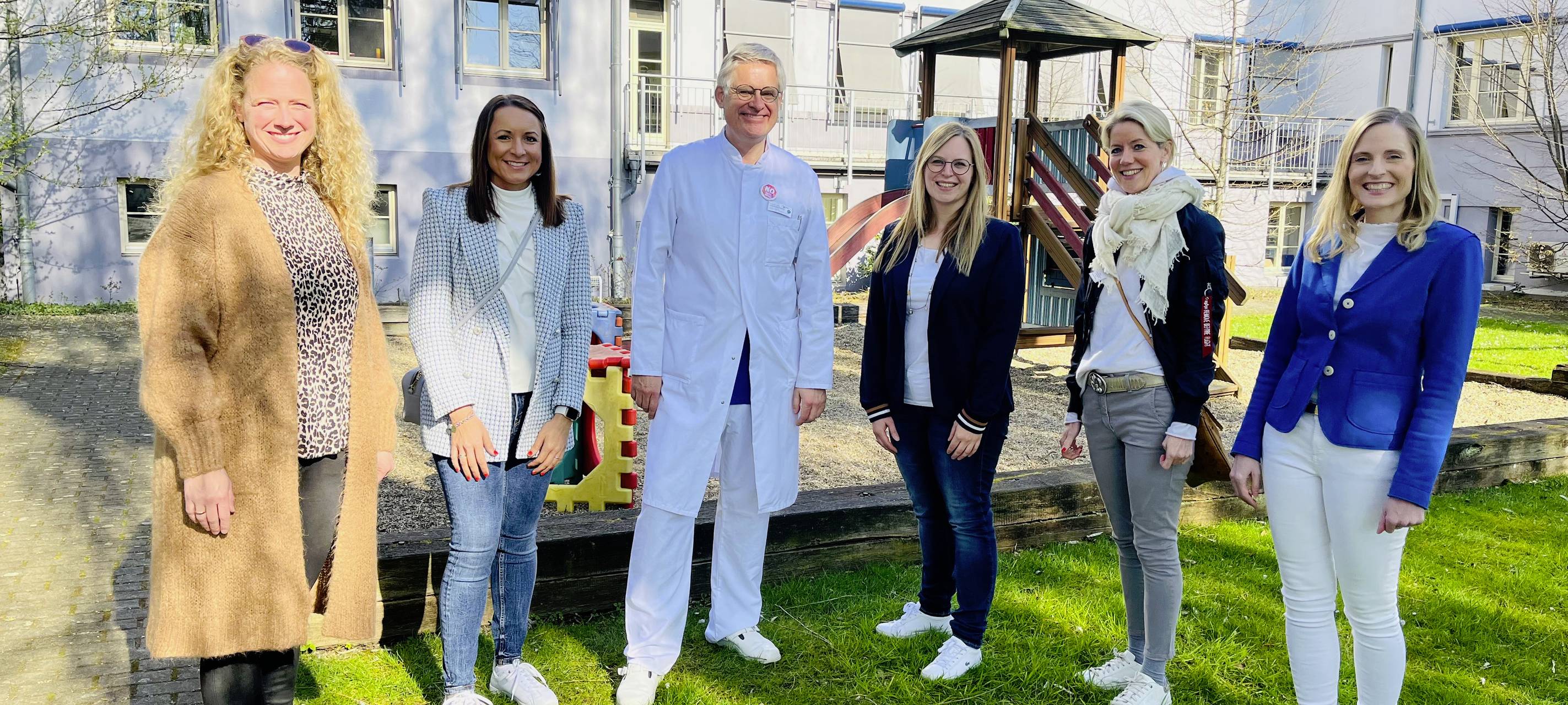 Chefarzt, Chefredakteurin und Fördervereinsmitglieder auf dem Spielplatzgelände