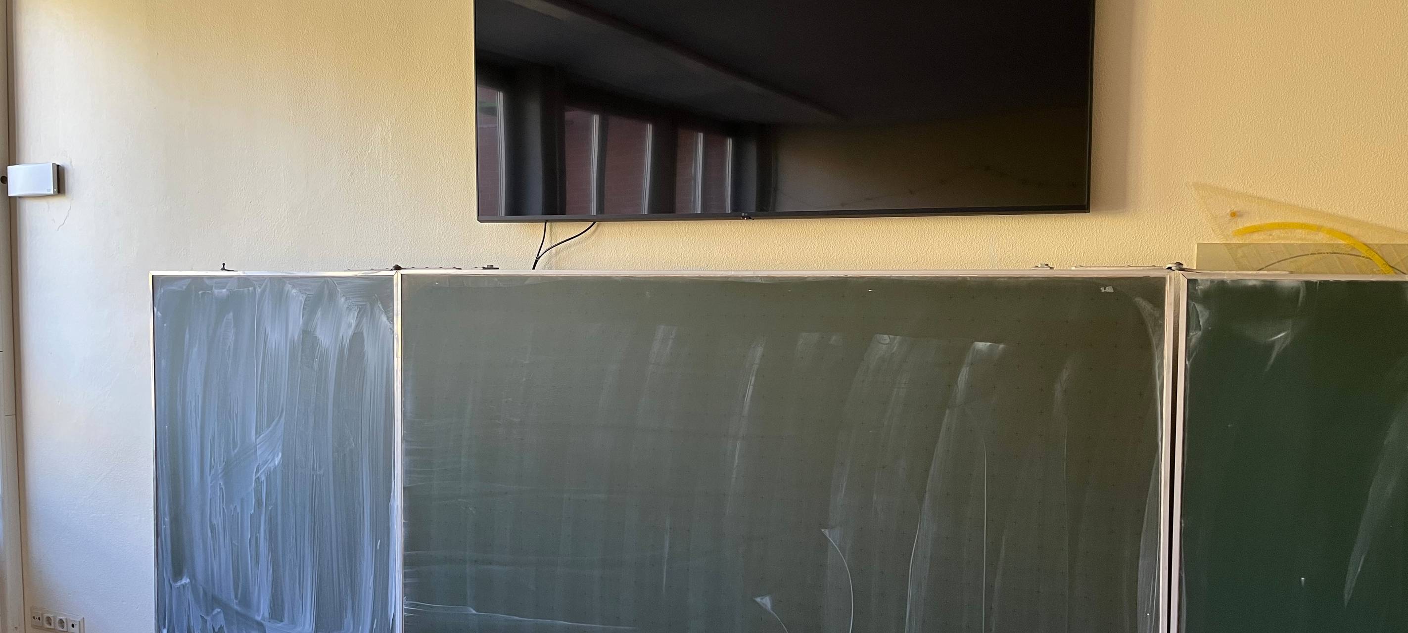 Ein Fernseher als digitale Tafel über einer normalen Tafel