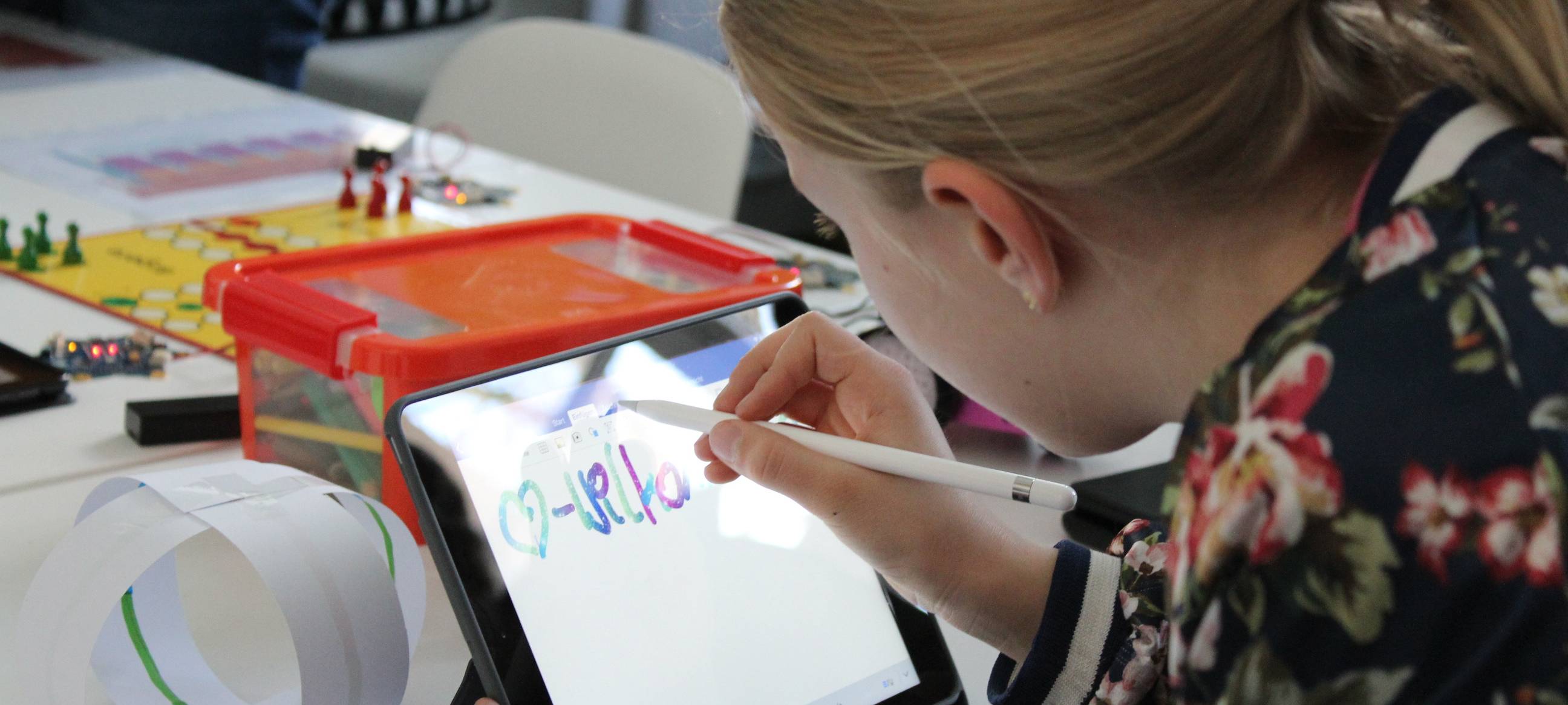 Eine Schülerin probiert ein Projekt auf dem Tablet aus.