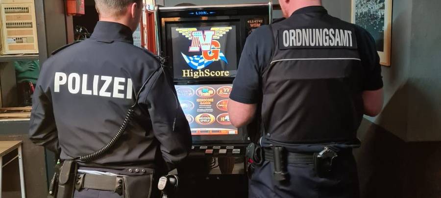 Polizist und Ordnungsamtmitarbeiter in Bar, vor Spielautomat