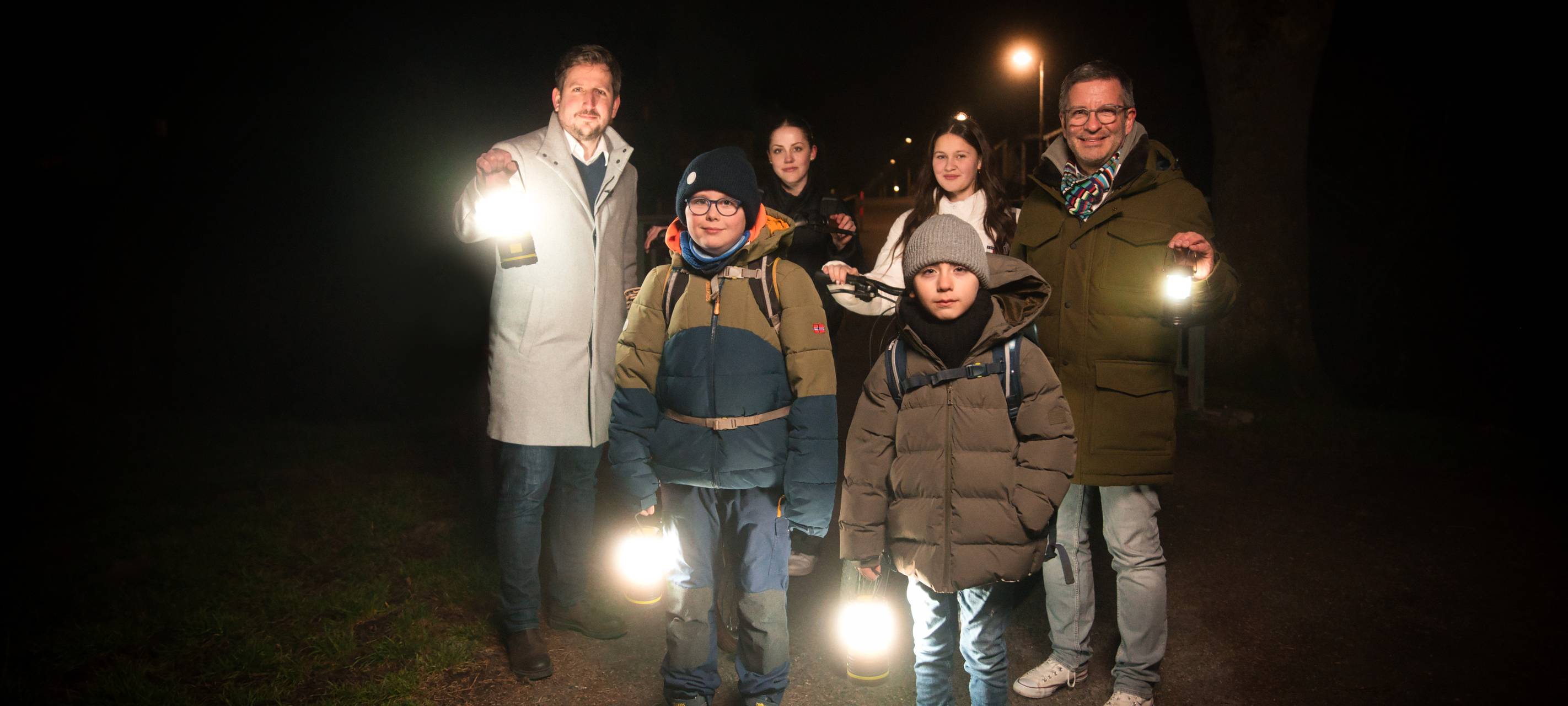 Menschen mit Taschenlampen im Dunkeln.