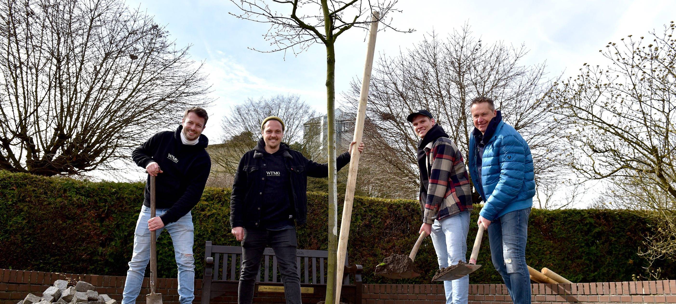 Das Team von WTMG beim Pflanzen eines Baumes.