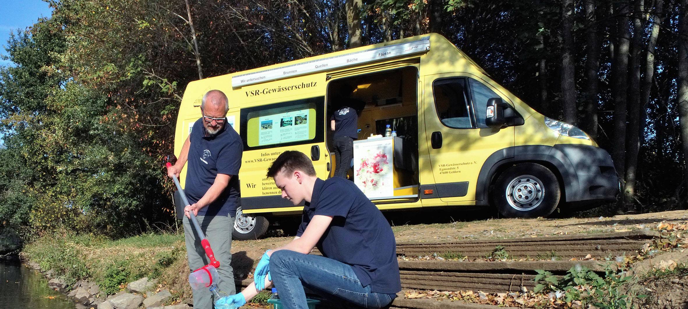 Harald Gützlow und Milan Toups entnehmen eine Wasserprobe.