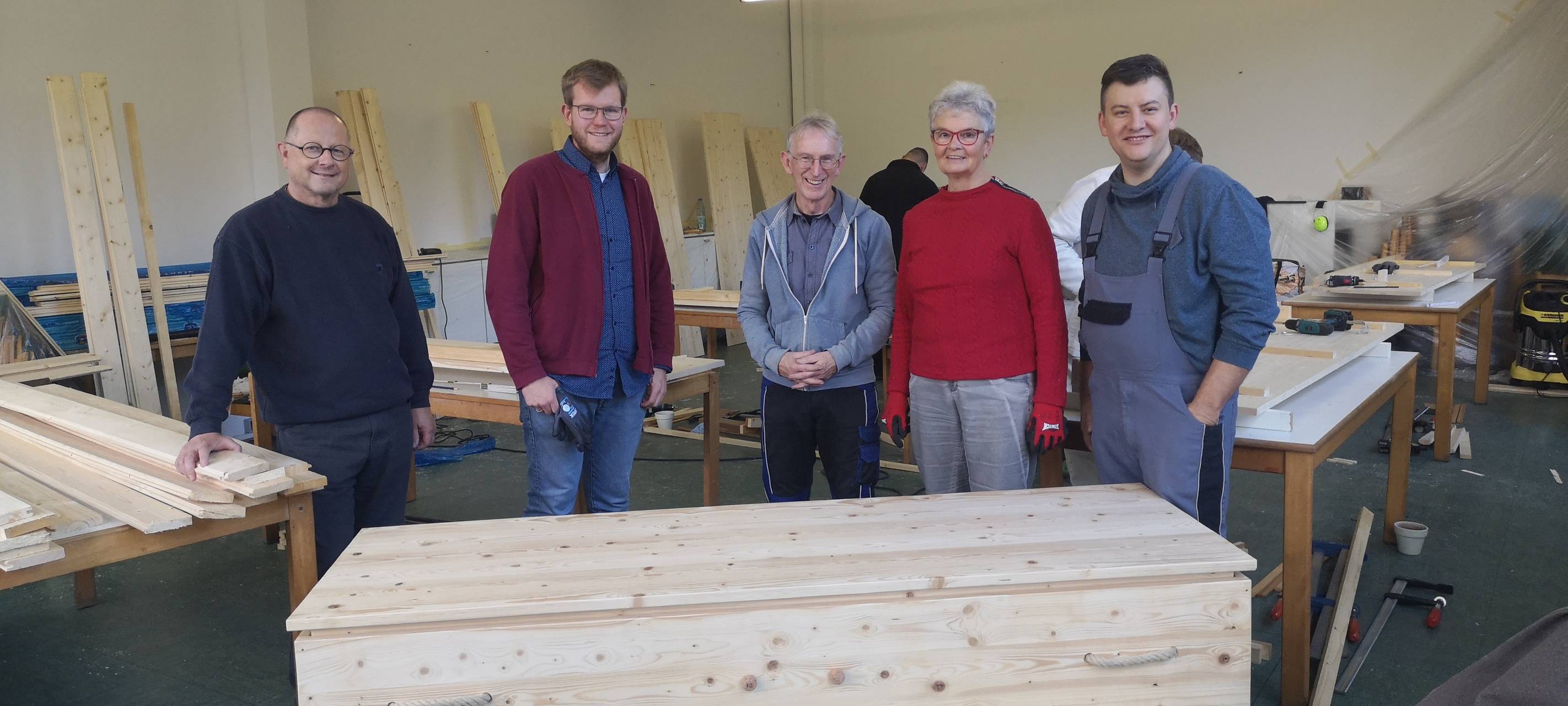 Die Teilnehmer des Sargbau-Workshops. Im Vordergrund ist einer der selbstgebauten Särge zu sehen.