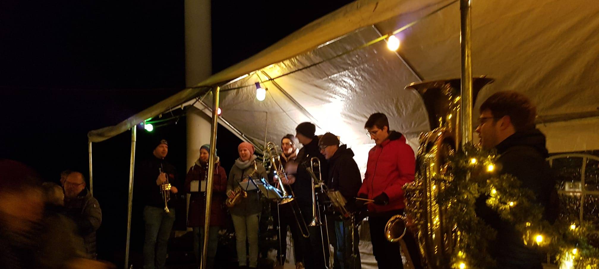 Bläser stehen auf dem Weihnachtsmarkt in Osttünnen auf einer Bühne.