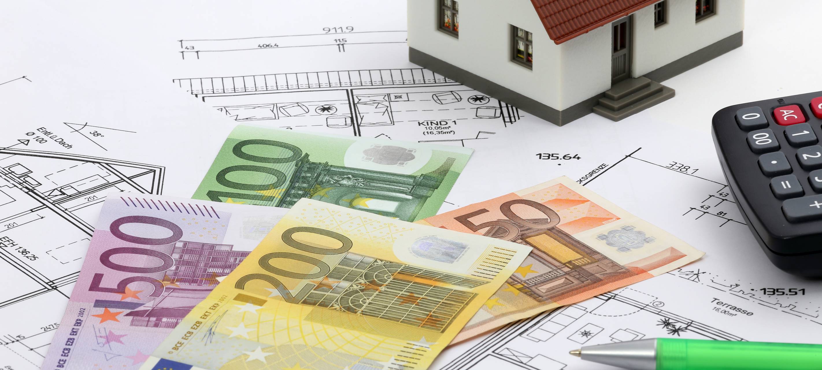 Modellhaus auf Bauplänen und davor Geldscheine