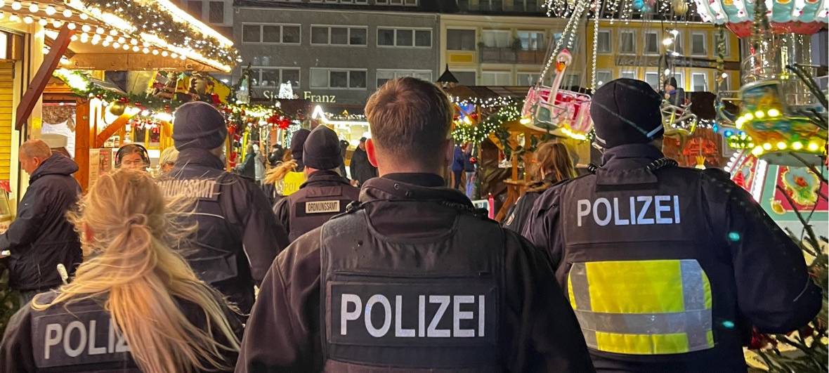 Polizisten auf dem Hammer Weihnachtsmarkt (von hinten).