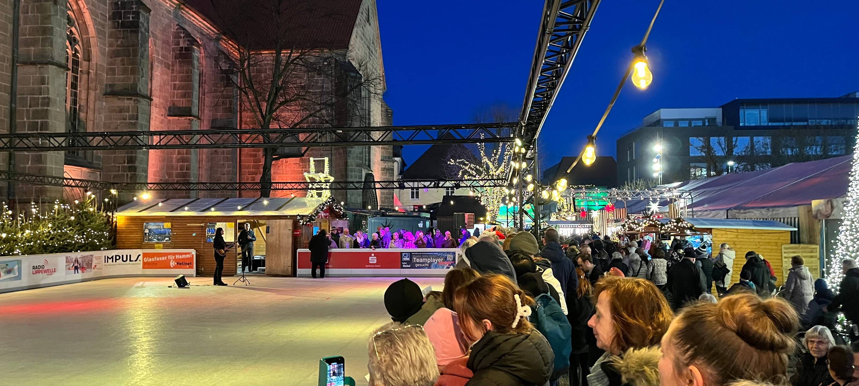 Die Hammer singen um die Eisbahn auf dem Hammer Weihnachtsmarkt mit Lippewelle-Moderatorin Simone Niewerth und Sänger Freddy Pieper.