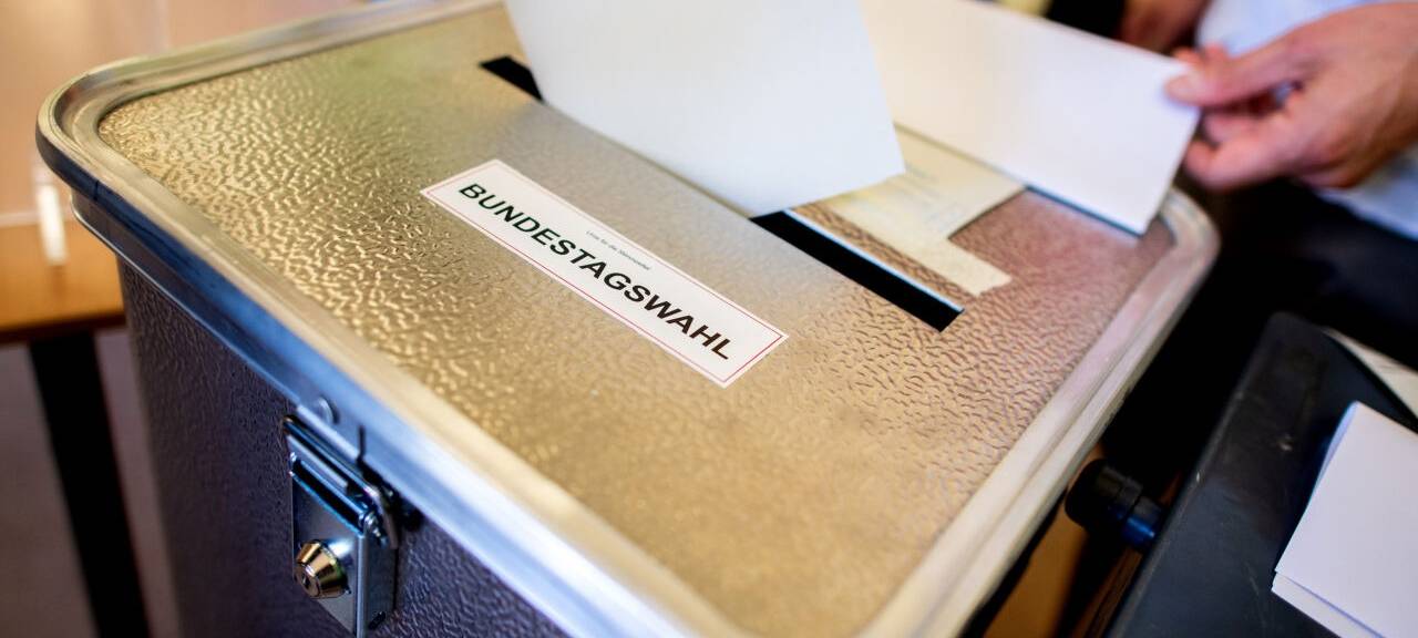 Ein Wähler wirft in einem Wahllokal, das im Klassenraum einer Grundschule im Stadtteil Prenzlauer Berg untergebracht ist, seinen Stimmzettel für die Bundestagswahl in eine Wahlurne. In Teilen von Berlin wird die Bundestagswahl vom September 2021 am Sonntag wiederholt. (zu dpa: «Wiedergutmachung, Teil zwei: Berlin wählt mal wieder»)