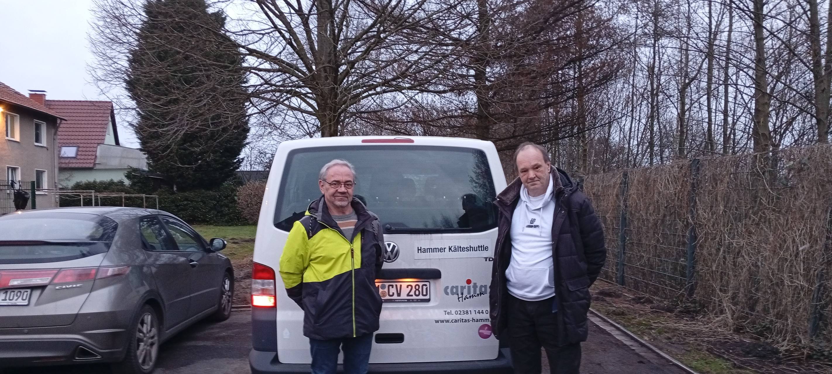 Berthold Schöpe (l.), Caritas-Fachbereichsleiter Soziale Dienste, und der Ehrenamtliche Michael Kuppe (r.) vor dem Kälteshuttle-Bus der Caritas Hamm.