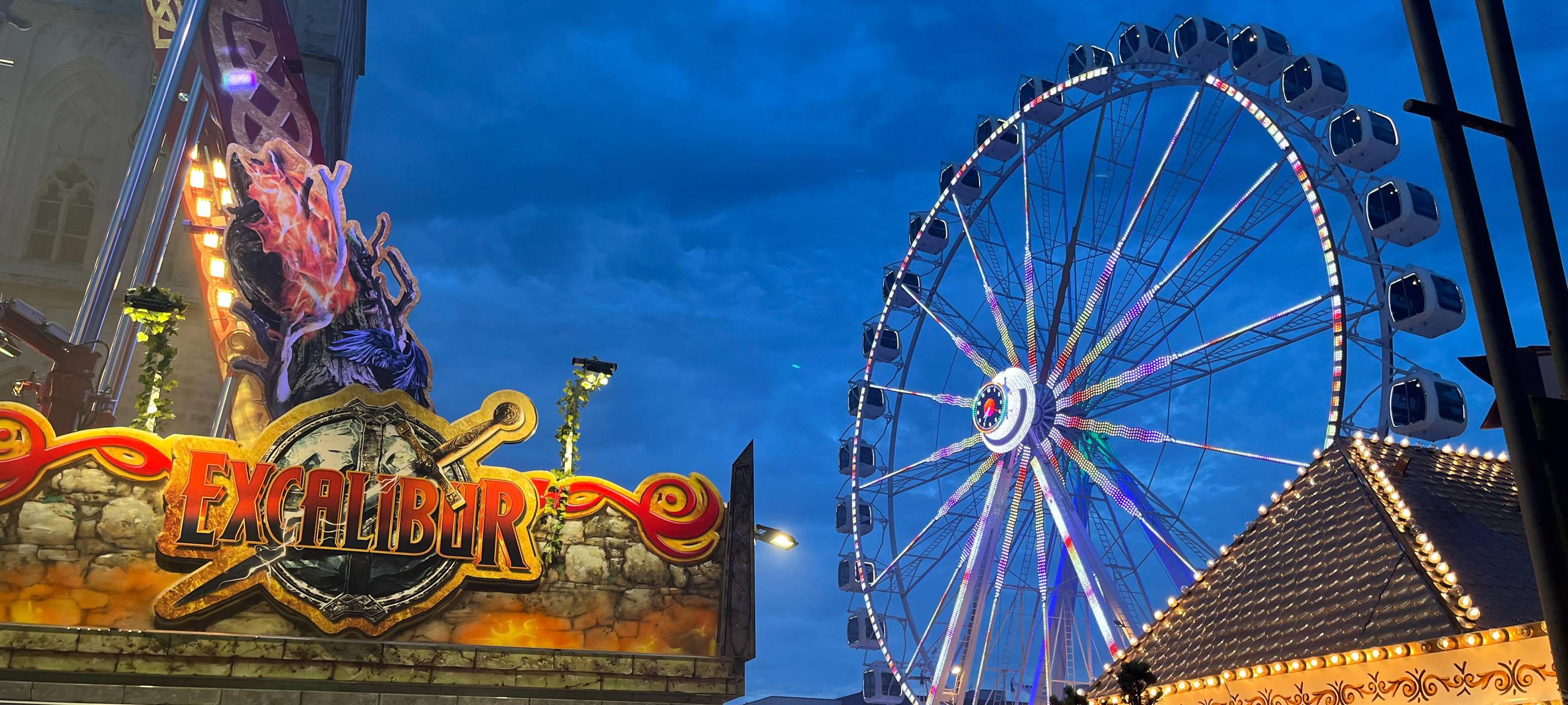 Zwei Fahrgeschäfte auf dem Stunikenmarkt in der Hammer Innenstadt bei Nacht. Im Vordergrund das Kassenhäuschen vom "Excalibur", im Hintergrund das Riesenrad mit seinen geschlossenen Kabinen