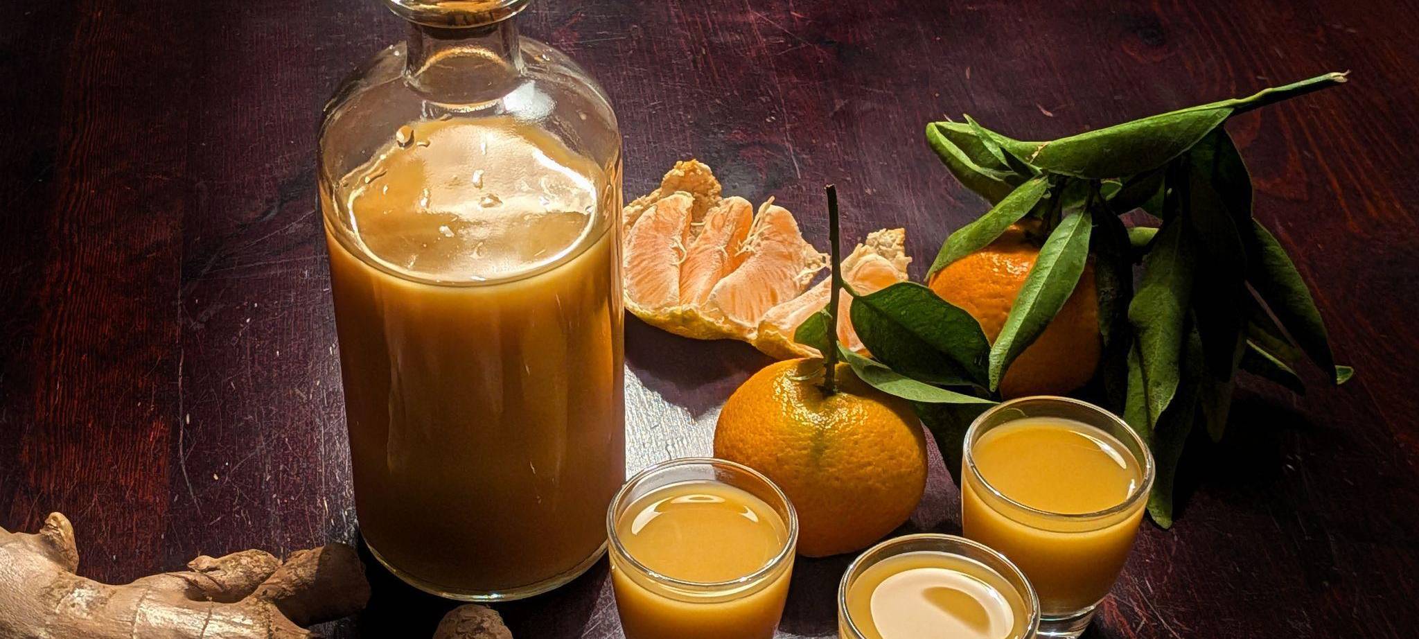 Eine Flasche und drei Gläser mit Ingwershot stehen auf dem Tisch