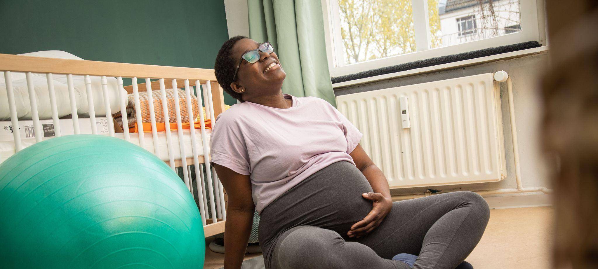 Eine schwangere Frau auf einer Yogamatte