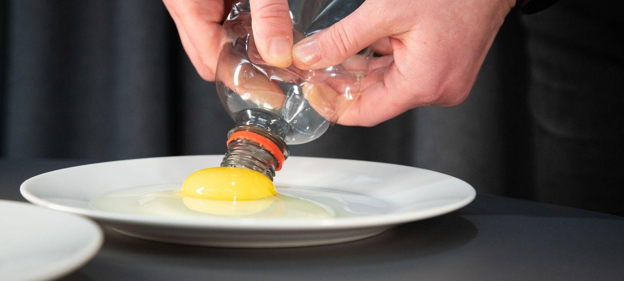 Flasche wird zusammengedrückt, um Eigelb von Eiweiß zu trennen