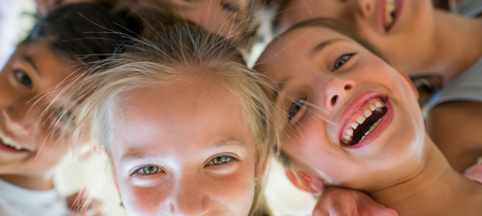 Eine Gruppe von Kindern steht im Kreis und lächelt.