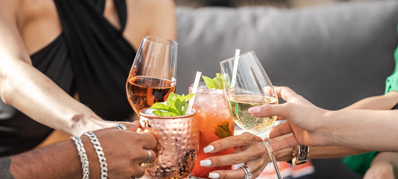 Eine Gruppe junger Menschen stößt mit ihren Getränken an.