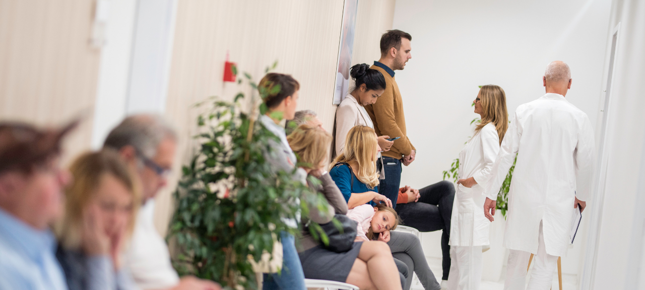 Menschen warten in einem Krankenhaus in der Notaufnahme auf einen Arzt.