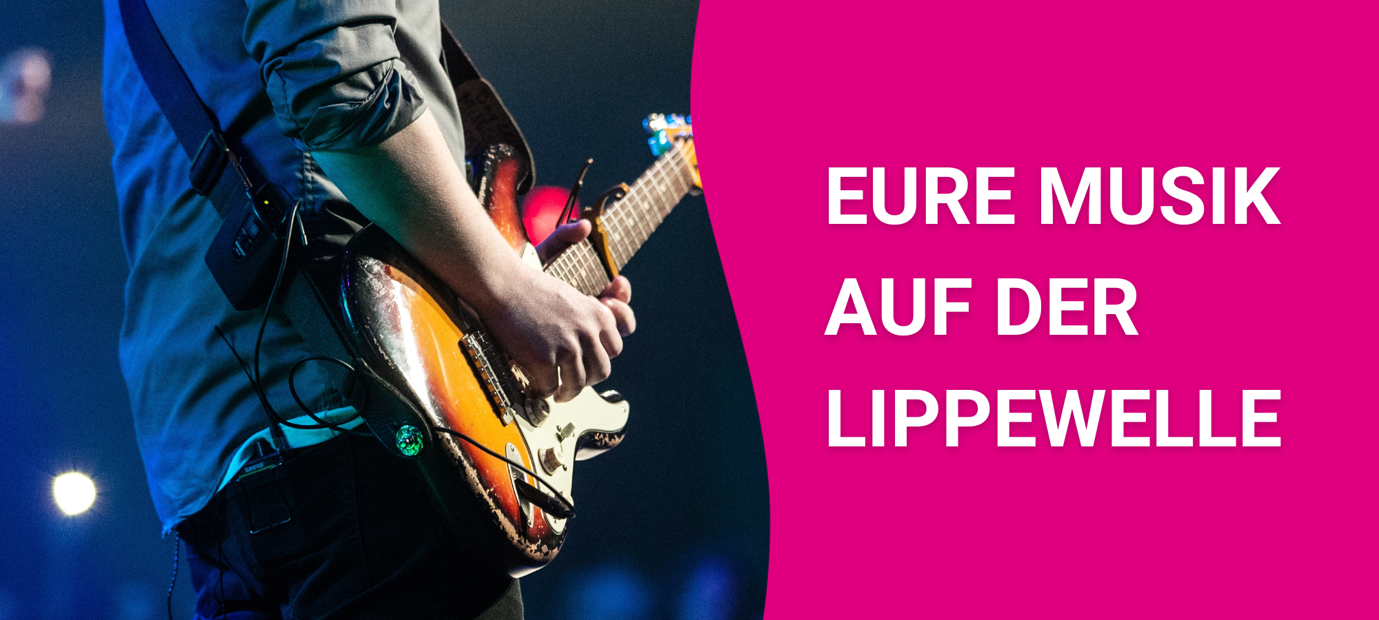 Ein Gitarrist performt mit dem Rücken zur Kamera auf der Bühne vor Publikum.